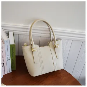 Detail of cream lychee texture bucket bag featuring gold hardware and stitching