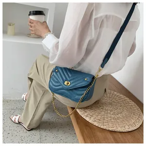 Sac bandoulière en cuir bleu matelassé avec fermoir rotatif doré et bandoulière large