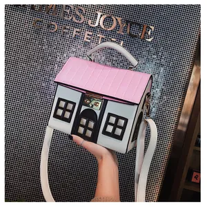 Detailed view of creative house-shaped crossbody bag featuring pink quilted roof and golden clasp