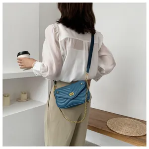 Sac bandoulière en cuir bleu matelassé avec fermoir rotatif doré et bandoulière large