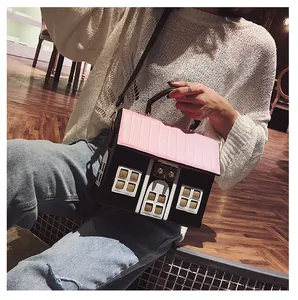 Detail view of a creative house-shaped crossbody bag with pink quilted roof and gold lock