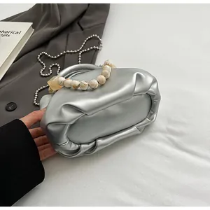 Gros plan du sac nuage plissé argenté avec poignée marbrée et bandoulière chaîne