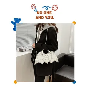 Detailed view of white bat-shaped Gothic bag with spider web embroidery and leather texture