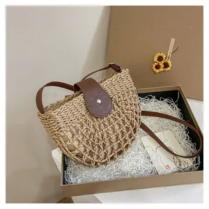 Vue détaillée du sac bandoulière en paille tressée avec sangle en cuir en coffret