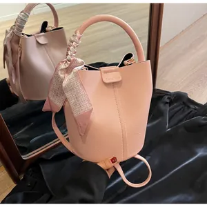 Pink bucket bag with lychee grain leather and decorative floral silk scarf handle