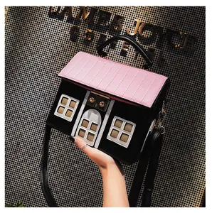 Detailed close-up of a house-shaped handbag in black PU leather with a pink quilted roof