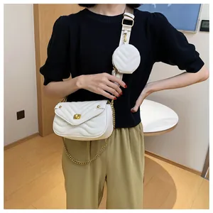 Detail van witte gewatteerde crossbodytas met gouden hardware en mini ronde portemonnee