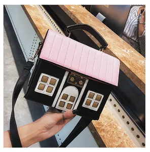 Detail of creative house-shaped crossbody bag featuring pink quilted roof and metal lock