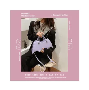 Detail of lavender bat-shaped PU leather bag with silver buckle on a stylish outfit