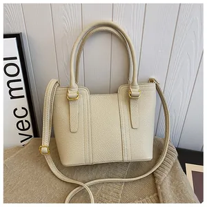 Detail showing the lychee grain texture and gold metal ring on this beige bucket bag