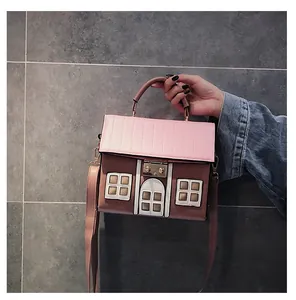 Detailed close-up of a house-shaped handbag with pink roof and brown PU leather accents