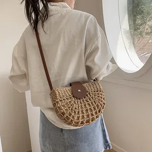 Sac bandoulière en paille tissée pour femme avec rabat en cuir brun et forme de selle