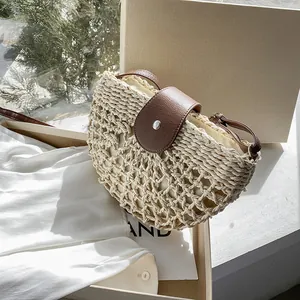 Sac bandoulière en paille demi-lune avec rabat en cuir marron et boucle argentée d'été