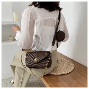 Détail du sac bandoulière matelassé marron foncé avec chaîne dorée et petit porte-monnaie