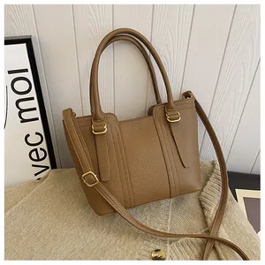 Detailed view of brown litchi grain leather texture and premium gold metal hardware hooks