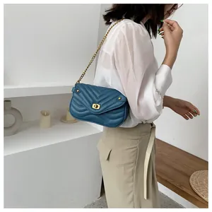 Détail du sac en cuir matelassé bleu marine avec coutures en V et fermoir doré