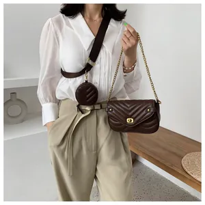 Detail van donkerbruine gewatteerde crossbodytas met brede riem en ronde portemonnee