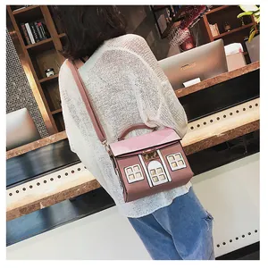 Creative house-shaped pink crossbody bag with 3D window details shown on a model