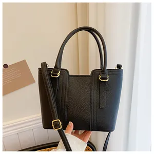 Close-up of black lychee grain leather bucket bag with elegant gold-tone metal hardware