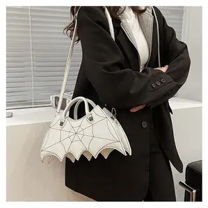 Detailed view of white bat-shaped gothic crossbody bag with spider web embroidery details