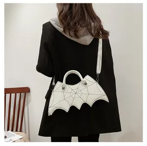 Detailed view of a white gothic bat-shaped handbag with black spiderweb patterns