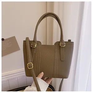Detail of dark brown lychee leather bucket bag with golden hardware and stitching
