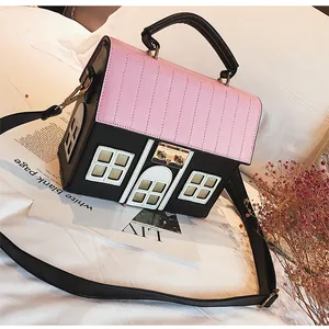 Detailed view of creative house-shaped handbag with pink roof flap and black leather body