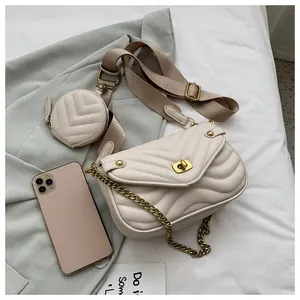 Detail van de beige gewatteerde handtas met brede riem en ronde kleine portemonnee
