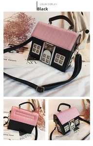 Detailed view of the house-shaped crossbody bag featuring pink roof and black faux leather