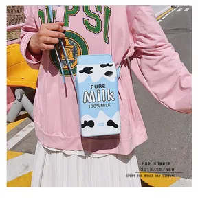 Détail du sac bandoulière en forme de brique de lait avec motif vache bleu et texte Pure Milk