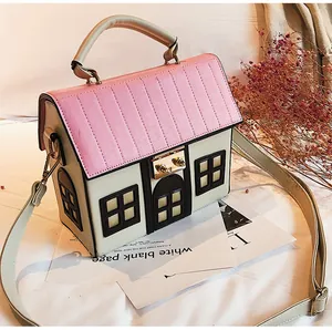Detailed close-up of a house-shaped pink and beige creative crossbody bag with metal lock