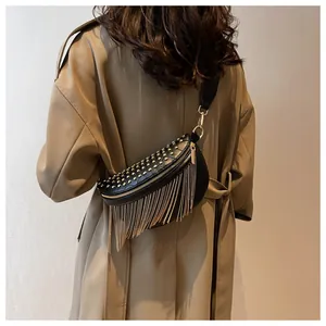 Detail of black leather chest bag with golden studs and long metal fringe tassels