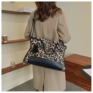 Leopard print tote bag detail showing metal rivets, black fringe and leather handles