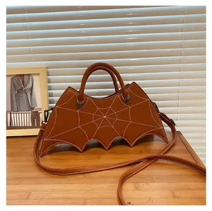 Detailed view of brown bat-shaped purse featuring embroidered spider web on matte PU leather