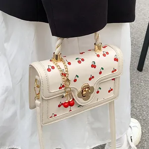 Chic cream small square bag with red cherry print, floral lock and rope handle