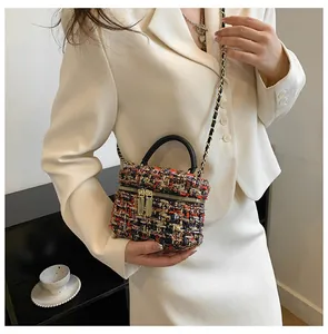 Detail van de veelkleurige tweed textuur en lederen handgreep aan de kleine crossbody tas