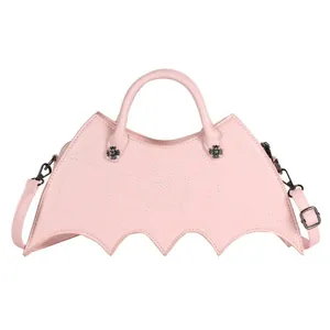 Detail of pink bat-shaped handbag with spider web stitching and metal cross rivets