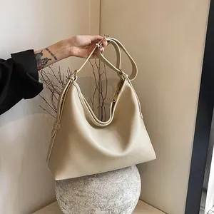 Dettaglio borsa hobo in pelle beige a grana di litchi con tracolla regolabile