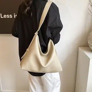 Borsa hobo bianco crema minimalista con tracolla larga vista sulla schiena del modello