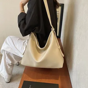 Dettaglio della borsa tote in pelle beige con texture litchi e fibbia sulla tracolla