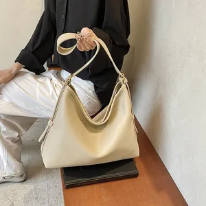Dettaglio della grande borsa hobo in pelle beige con trama martellata e tracolla morbida