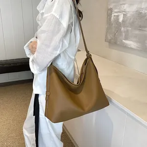 Borsa tote in pelle color caramello indossata da modella per riferimento taglia