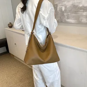 Dettaglio della borsa tote marrone in pelle martellata con tracolla per l'uso quotidiano