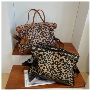 Detail of leopard print canvas tote bags with metallic rivets and fringe tassel accents