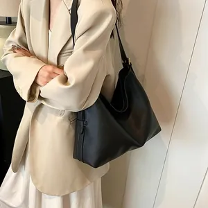 Vista dettagliata della borsa hobo nera con trama litchi indossata da una modella
