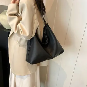 Dettaglio di una borsa hobo nera in pelle martellata indossata da una modella