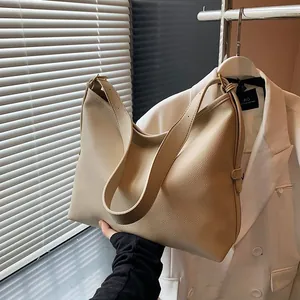 Dettaglio borsa hobo crema con trama a grana e ampia tracolla regolabile moderna