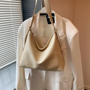 Dettaglio borsa hobo in pelle beige a grana con texture litchi per un look da ufficio