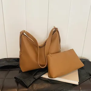 Dettaglio della borsa hobo marrone con trama litchi, pochette coordinata e finiture dorate