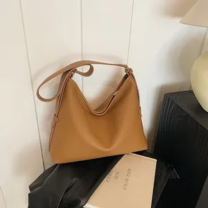 Dettaglio ravvicinato della borsa tote in pelle martellata caramello con tracolla